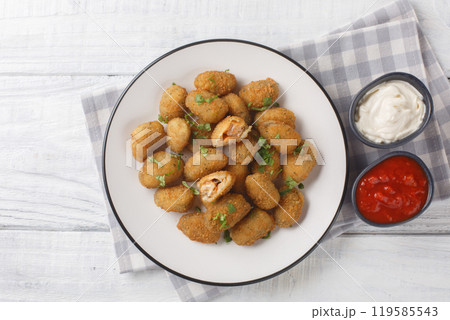 Delicious fresh breaded mussels served with mayonnaise and ketchup close-up in a plate. Horizontal top view Delicious fresh breaded mussels served with mayonnaise and ketchup close-up in a plate. Horizontal top view 119585543