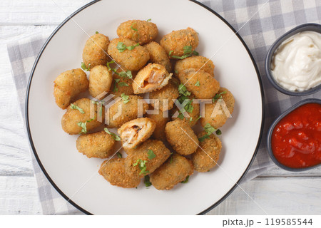 Seafood appetizer breaded mussels served with mayonnaise and ketchup close-up in a plate. Horizontal top view 119585544
