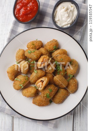 Appetizer Fried breaded mussels served with mayonnaise and ketchup close-up in a plate. Vertical top view Appetizer Fried breaded mussels served with mayonnaise and ketchup close-up in a plate. Vertical top view 119585547