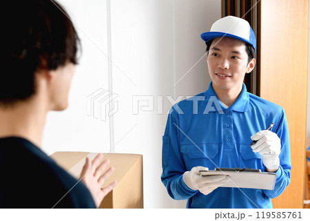 部屋で会話をする男性作業員と若い男性客 部屋で会話をする男性作業員と若い男性客 119585761