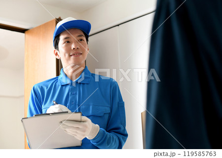 部屋で会話をする男性作業員と若い男性客 119585763