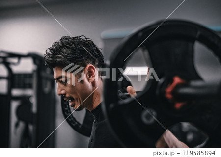 ジムでバーベルでウェイトトレーニングする男性 119585894