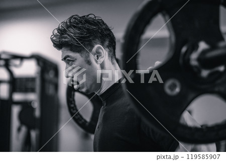 ジムでバーベルでウェイトトレーニングする男性 119585907