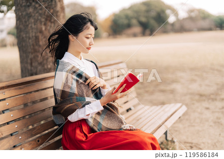 屋外で読書をする女性 119586184