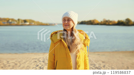 Traveler woman looking away on sunny beach, enjoying landscape on sea coast, nature background 119586837