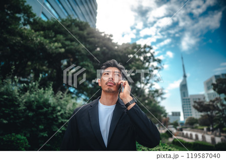 ビル群でスマホを持つ男性 119587040