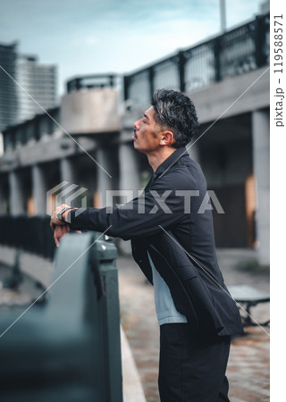 橋で真剣な表情で黄昏ている男性 橋で真剣な表情で黄昏ている男性 119588571