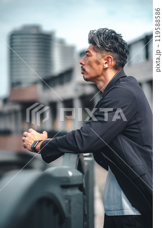 橋で真剣な表情で黄昏ている男性 119588586