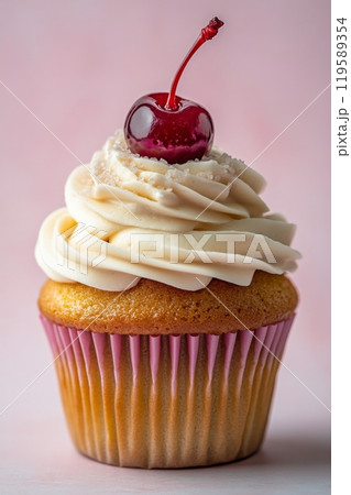 Delicious vanilla cupcake topped with cream frosting and a cherry on pink background 119589354