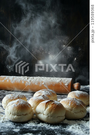 A rolling pin rests beside freshly baked bread on a table dusted with flour A rolling pin rests beside freshly baked bread on a table dusted with flour 119589368
