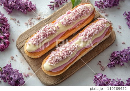 Delicate pastries topped with colorful frosting and sprinkles surrounded by lilac flowers 119589422