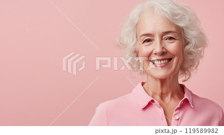 ピンクのシンプル背景に笑顔を見せるシニア女性 ピンクのシンプル背景に笑顔を見せるシニア女性 119589982