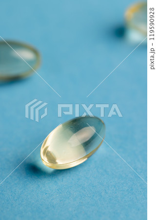 transparent fish oil capsules on blue paper 119590928