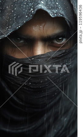 Close up of a mysterious figure with intense eyes wearing a dark cloth in a rainy environment 119596436