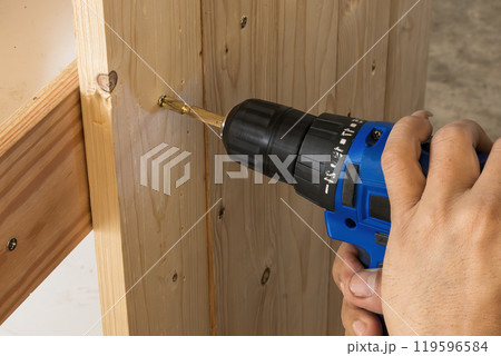 Close up scene the power screw driver working with wooden plank. Close up scene the power screw driver working with wooden plank. 119596584