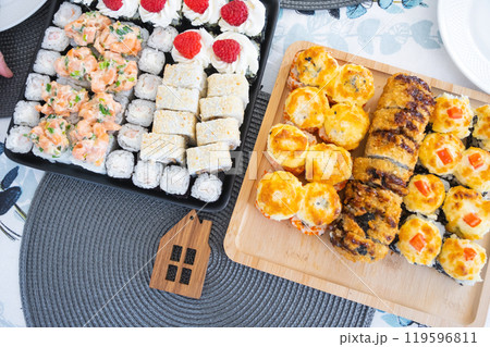 Delivery of sushi and rolls set top view on the table at home on a napkin, home cooking Delivery of sushi and rolls set top view on the table at home on a napkin, home cooking 119596811