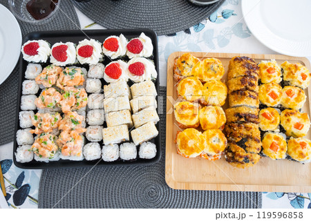 Delivery of sushi and rolls set top view on the table at home on a napkin, home cooking 119596858