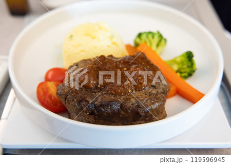 おいしいビジネスクラスの機内食、牛ヒレ肉のステーキマスタードソースがけ、ジャガイモのピュレ 119596945