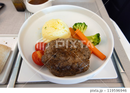 おいしいビジネスクラスの機内食、牛ヒレ肉のステーキマスタードソースがけ、ジャガイモのピュレ 119596946