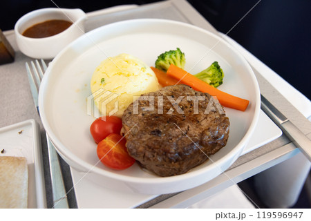 おいしいビジネスクラスの機内食、牛ヒレ肉のステーキマスタードソースがけ、ジャガイモのピュレ 119596947