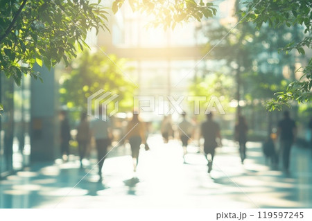 Blurred background of people walking in a modern building with green trees and sunlight. 119597245