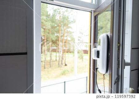 A window cleaner robot cleans windows in a house from the outside. Cleaning assistant, safe window cleaning, remote control A window cleaner robot cleans windows in a house from the outside. Cleaning assistant, safe window cleaning, remote control 119597392