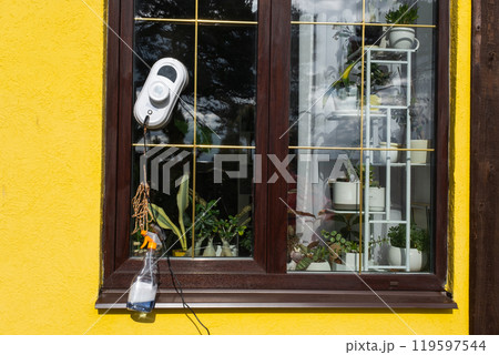 A window cleaner robot cleans windows in a house from the outside. Cleaning assistant, safe window cleaning, remote control 119597544