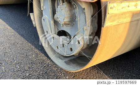 Asphalt paving roller. Road roller laying fresh asphalt, working on the new road construction site 119597669
