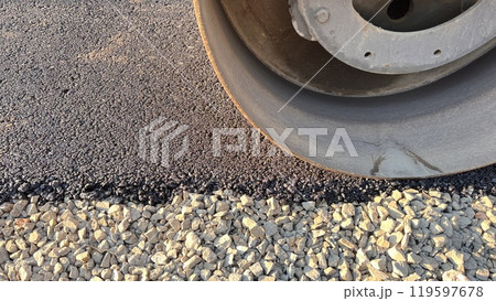 Asphalt paving roller. Road roller laying fresh asphalt, working on the new road construction site 119597678
