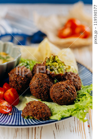 Falafel plate with hummus, cherry tomatoes, lettuce, and pita chips, perfect Mediterranean meal Falafel plate with hummus, cherry tomatoes, lettuce, and pita chips, perfect Mediterranean meal 119598577