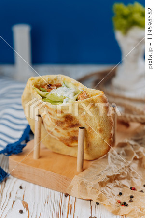 Fresh pita wrap with grilled chicken, lettuce, and creamy sauce for a perfect handheld meal 119598582