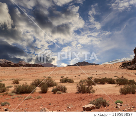 Wadi Rum Desert also known as The Valley of the Moon (against the sky with clouds)-- is a valley cut into the sandstone and granite rock in southern Jordan 60 km to the east of Aqaba Wadi Rum Desert also known as The Valley of the Moon (against the sky with clouds)-- is a valley cut into the sandstone and granite rock in southern Jordan 60 km to the east of Aqaba 119599857
