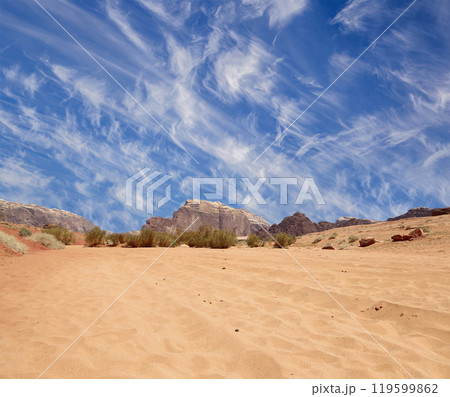 Wadi Rum Desert also known as The Valley of the Moon (against the sky with clouds)-- is a valley cut into the sandstone and granite rock in southern Jordan 60 km to the east of Aqaba 119599862