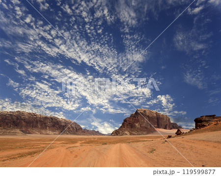 Wadi Rum Desert also known as The Valley of the Moon (against the sky with clouds)-- is a valley cut into the sandstone and granite rock in southern Jordan 60 km to the east of Aqaba 119599877