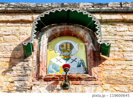 Icon of St. Nicholas the Wonderworker on the wall of an ancient temple 119600645