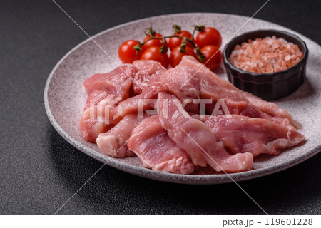 A pieces of raw fresh pork on a wooden cutting board with spices and herbs A pieces of raw fresh pork on a wooden cutting board with spices and herbs 119601228