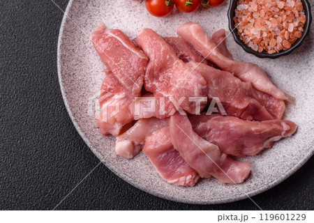 A pieces of raw fresh pork on a wooden cutting board with spices and herbs A pieces of raw fresh pork on a wooden cutting board with spices and herbs 119601229