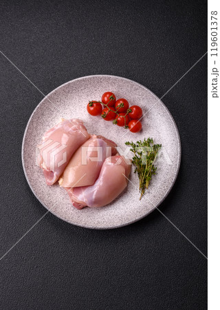 Fresh chicken fillet on a dark concrete table with spices and herbs Fresh chicken fillet on a dark concrete table with spices and herbs 119601378