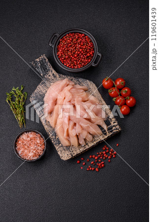 Raw chicken fillet cut into strips with spices and herbs 119601439
