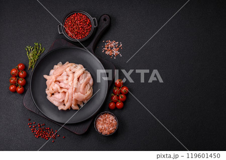 Raw chicken fillet cut into strips with spices and herbs 119601450
