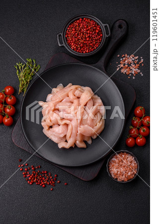 Raw chicken fillet cut into strips with spices and herbs 119601451