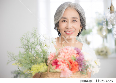 花を持つシニア女性のカメラ目線　誕生日や敬老の日母の日など 119605225