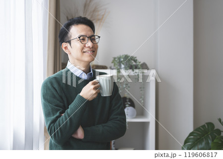 マグカップで飲み物を飲む30代後半の男性 119606817