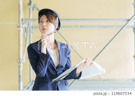 建設現場で図面を見る女性ビジネスマン（スーツ・工事・現場監督） 119607534