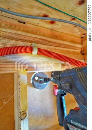 住宅で排水管を通すためにドリルで穴を開ける作業の様子 住宅で排水管を通すためにドリルで穴を開ける作業の様子 119607790