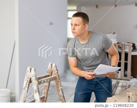 Teenage boy checking documents in construction site Teenage boy checking documents in construction site 119608220