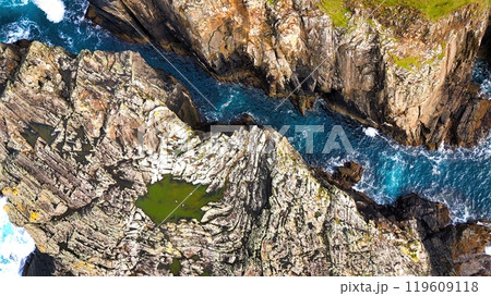Stunning Aerial View of Vibrant Turquoise Waves Elegantly Crashing Against Rocky Shoreline Stunning Aerial View of Vibrant Turquoise Waves Elegantly Crashing Against Rocky Shoreline 119609118