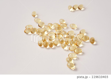Scattered transparent capsules on white background highlighting health 119610403