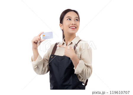 Portrait happiness young asian woman wearing apron holding and pointing credit card isolated. 119610707