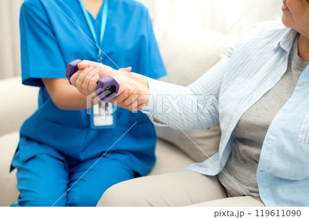 Asian caregiver woman or nurse training senior woman lifting dumbbell for arm exercise while therapy 119611090